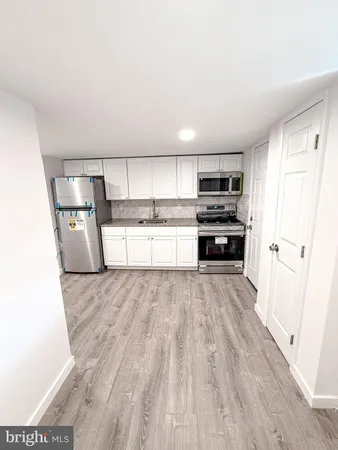 a kitchen with granite countertop a sink and a stove top oven