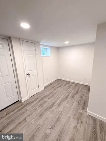 a view of kitchen with stainless steel appliances wooden floor and window