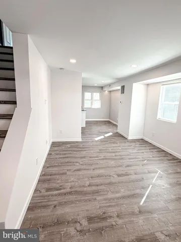 a large white kitchen with wooden floors and stove