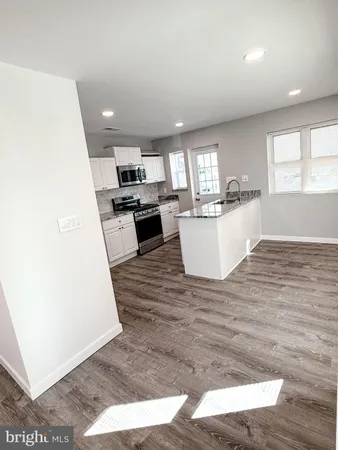 a kitchen with granite countertop a sink and a stove top oven
