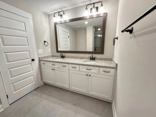 a bathroom with a granite countertop sink double and mirror