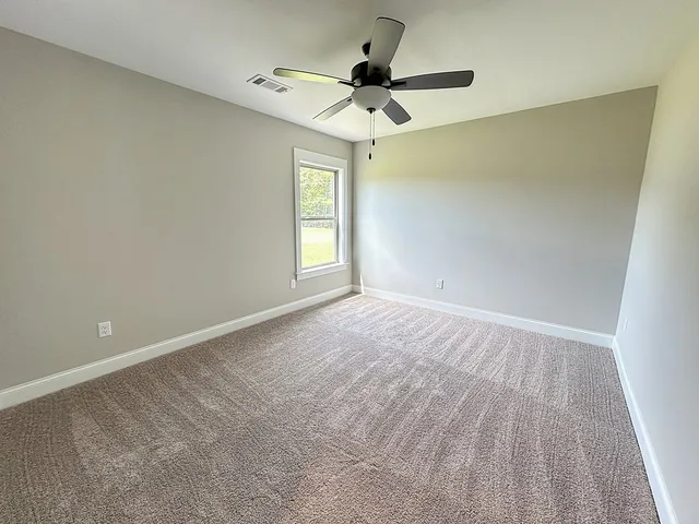 an empty room with a window and a fan