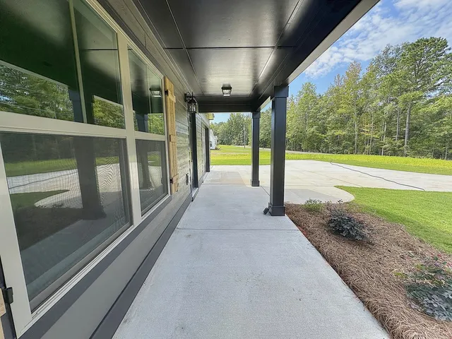a view of a room with wooden floor ceiling fan and windows
