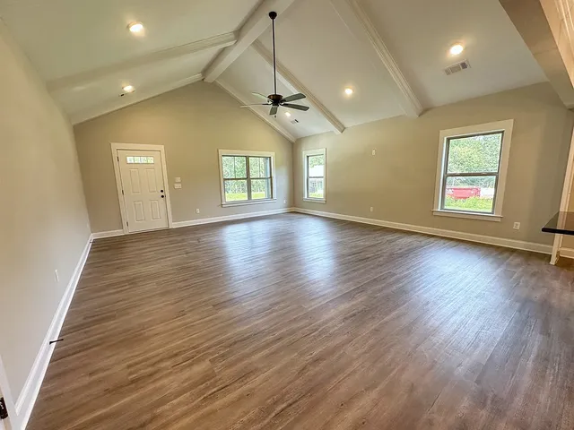 an open kitchen with wooden floor and stainless steel appliances