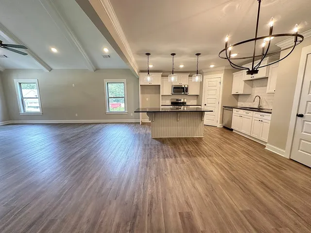 a large kitchen with cabinets wooden floor and stainless steel appliances