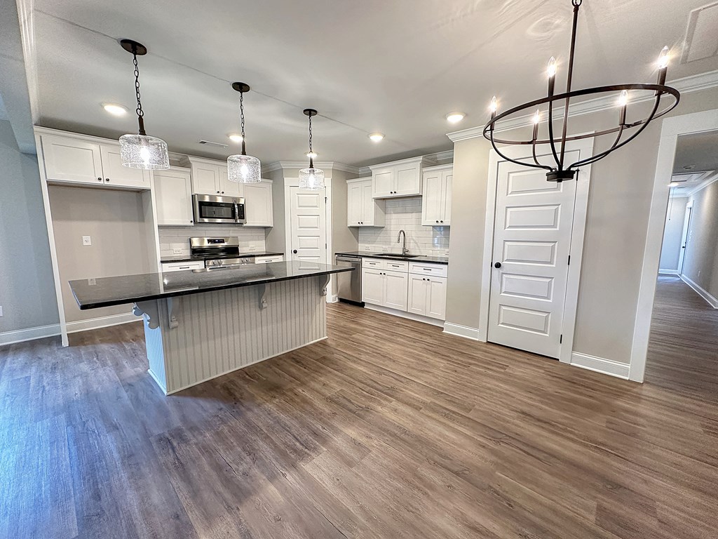 270 Young Lane Hamilton, GA 31811 - Photo 8 of 28 a kitchen with stainless steel appliances kitchen island hardwood floor sink and stove