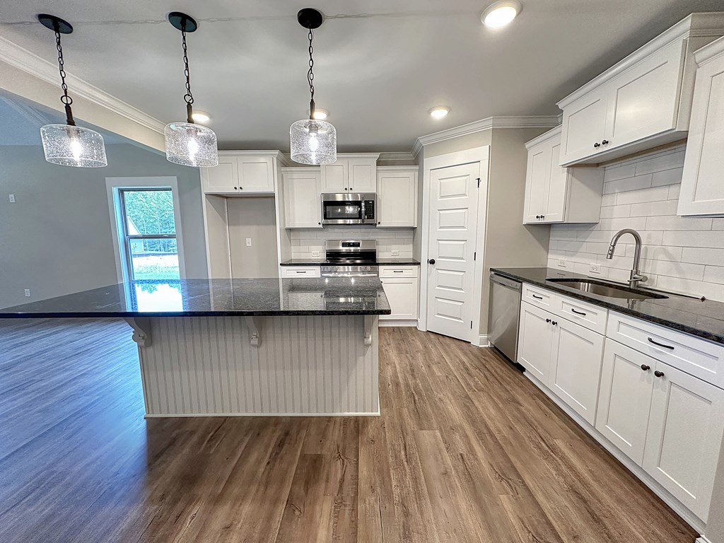 270 Young Lane Hamilton, GA 31811 - Photo 10 of 28 a kitchen with stainless steel appliances granite countertop wooden floors sink and cabinets
