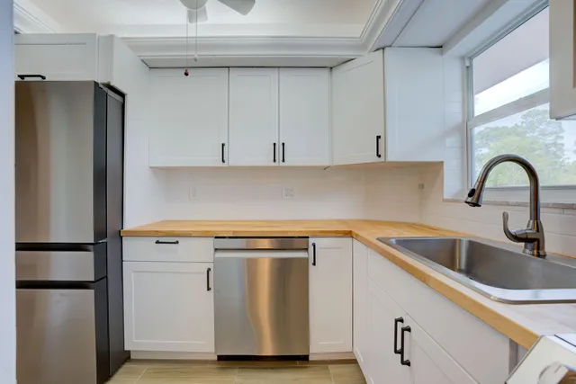 a kitchen with a refrigerator sink and cabinets