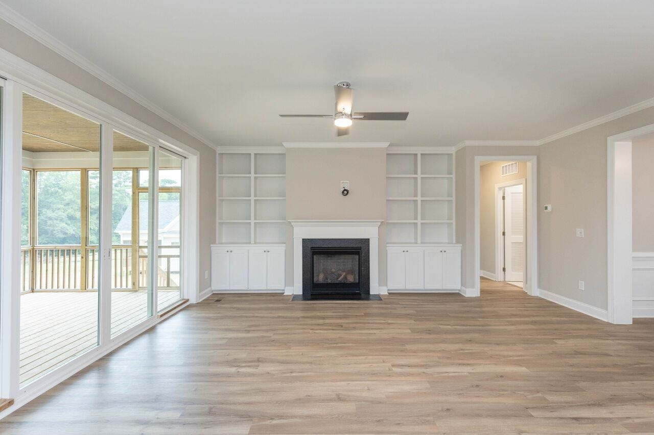 9616 Chris Drive Raleigh, NC 27603 - Photo 17 of 42 wooden floor fireplace and windows in an empty room
