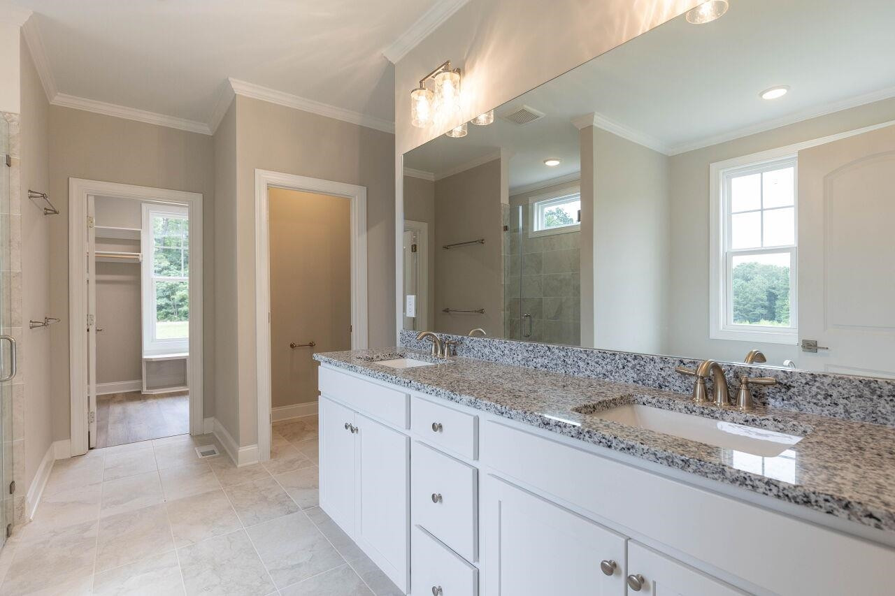 9616 Chris Drive Raleigh, NC 27603 - Photo 27 of 42 a bathroom with double sink and a mirror