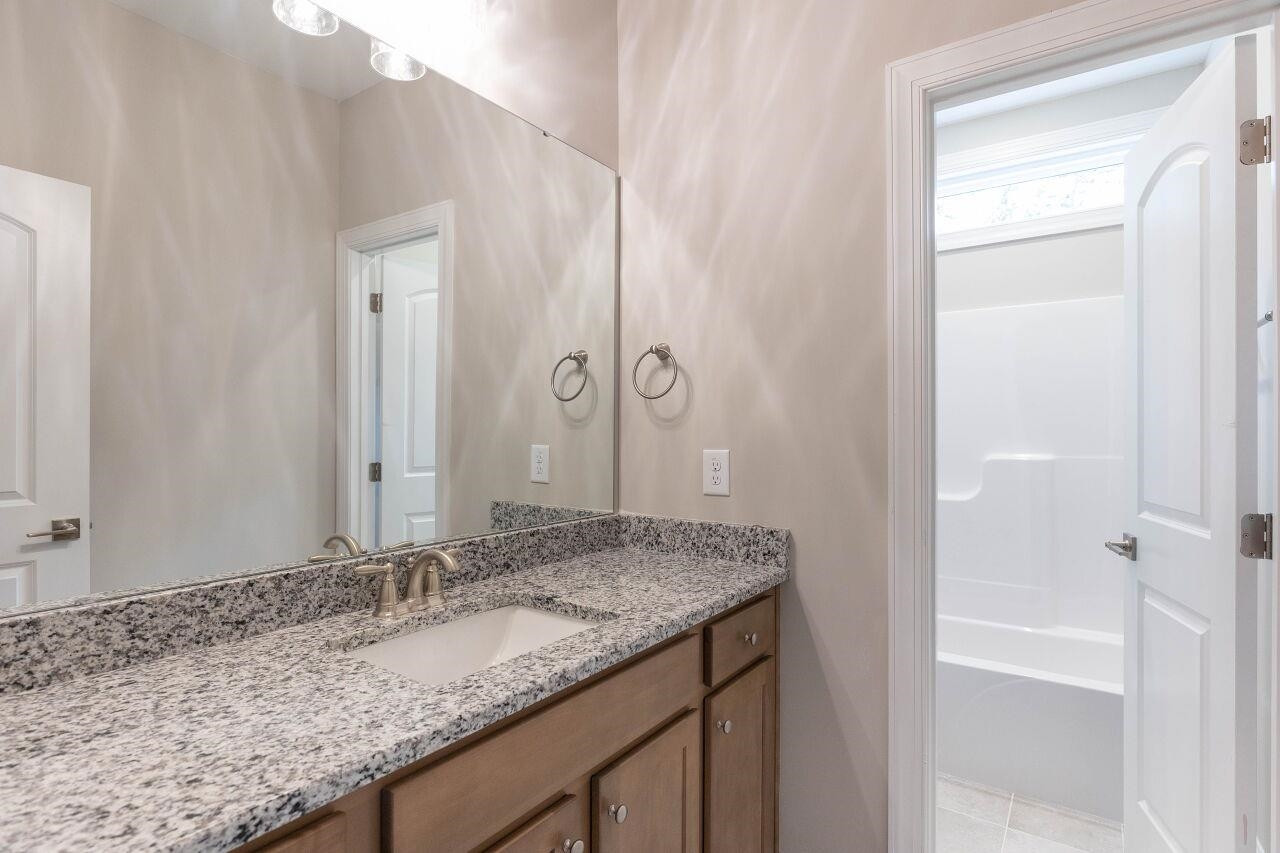 9616 Chris Drive Raleigh, NC 27603 - Photo 4 of 42 a bathroom with a granite countertop sink and a mirror