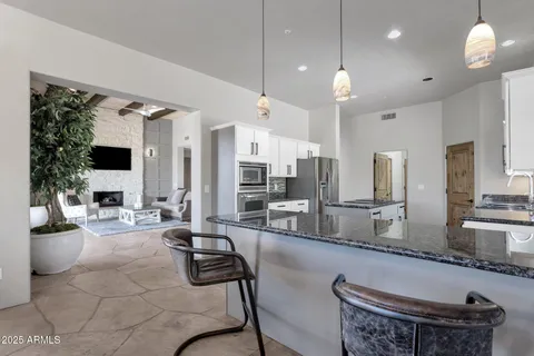 a kitchen with stainless steel appliances granite countertop a stove top oven a refrigerator a sink and dishwasher