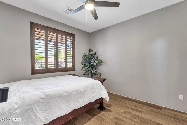 a bed sitting in a spacious bedroom next to a window