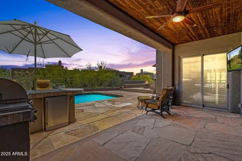 a view of swimming pool with seating area and trees in the background