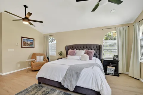 a bedroom with a bed wooden floor and window