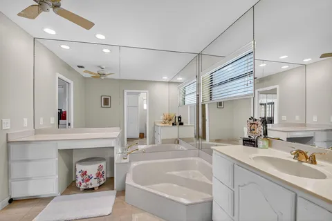 a bathroom with a tub sink and mirror