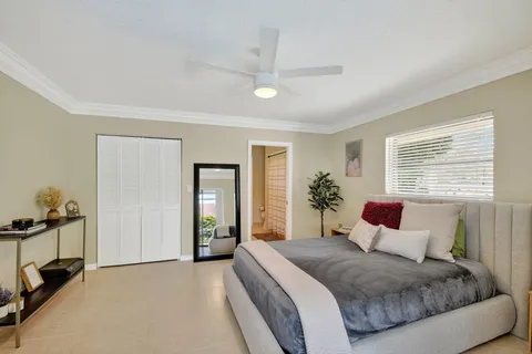 a bedroom with a balcony a bed and a dresser