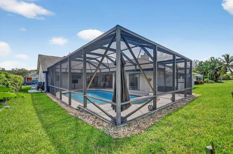 a wooden bench sitting in front of a house with a yard