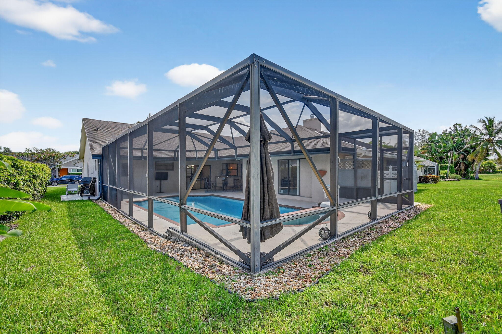 4270 Fox Trace Road Boynton Beach, FL 33436 - Photo 38 of 46 a wooden bench sitting in front of a house with a yard