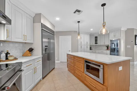 a kitchen with stainless steel appliances granite countertop a sink a stove and a refrigerator