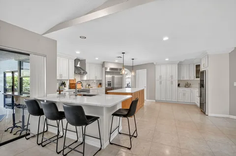 a kitchen with a dining table chairs and refrigerator