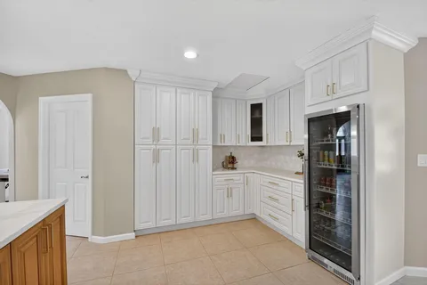 a kitchen with white cabinets and refrigerator