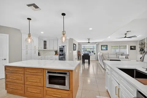 a large kitchen with stainless steel appliances kitchen island granite countertop a sink and cabinets