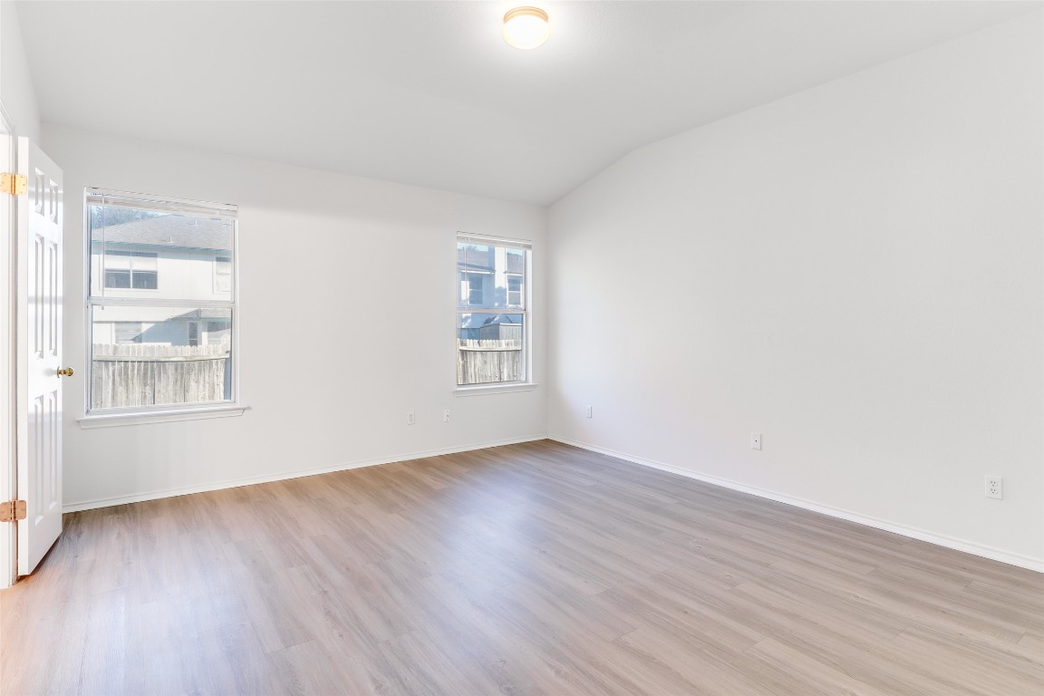 15437 Ozone Place Austin, TX 78728 - Photo 11 of 21 an empty room with wooden floor and windows