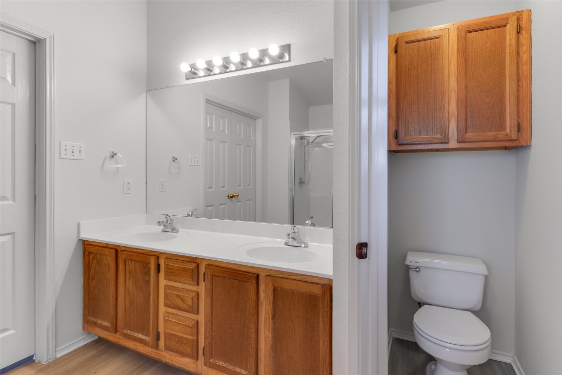 15437 Ozone Place Austin, TX 78728 - Photo 14 of 21 a bathroom with a toilet a sink a mirror and shower