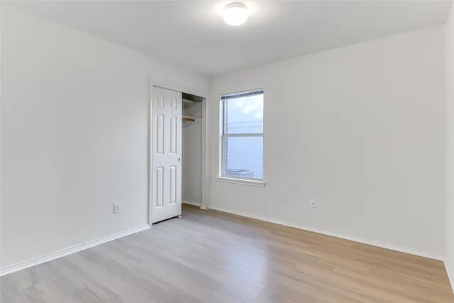 an empty room with wooden floor and mirror