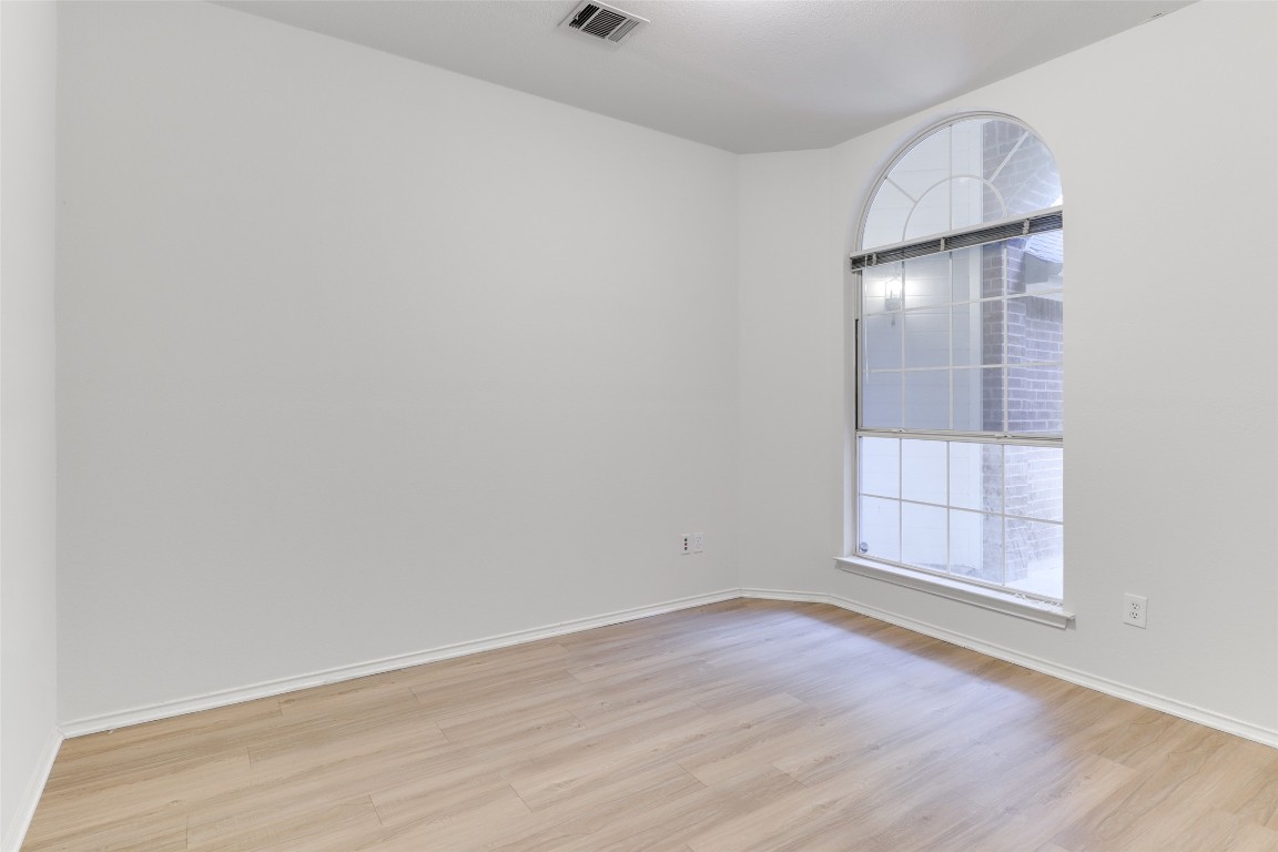 15437 Ozone Place Austin, TX 78728 - Photo 18 of 21 an empty room with wooden floor and mirror