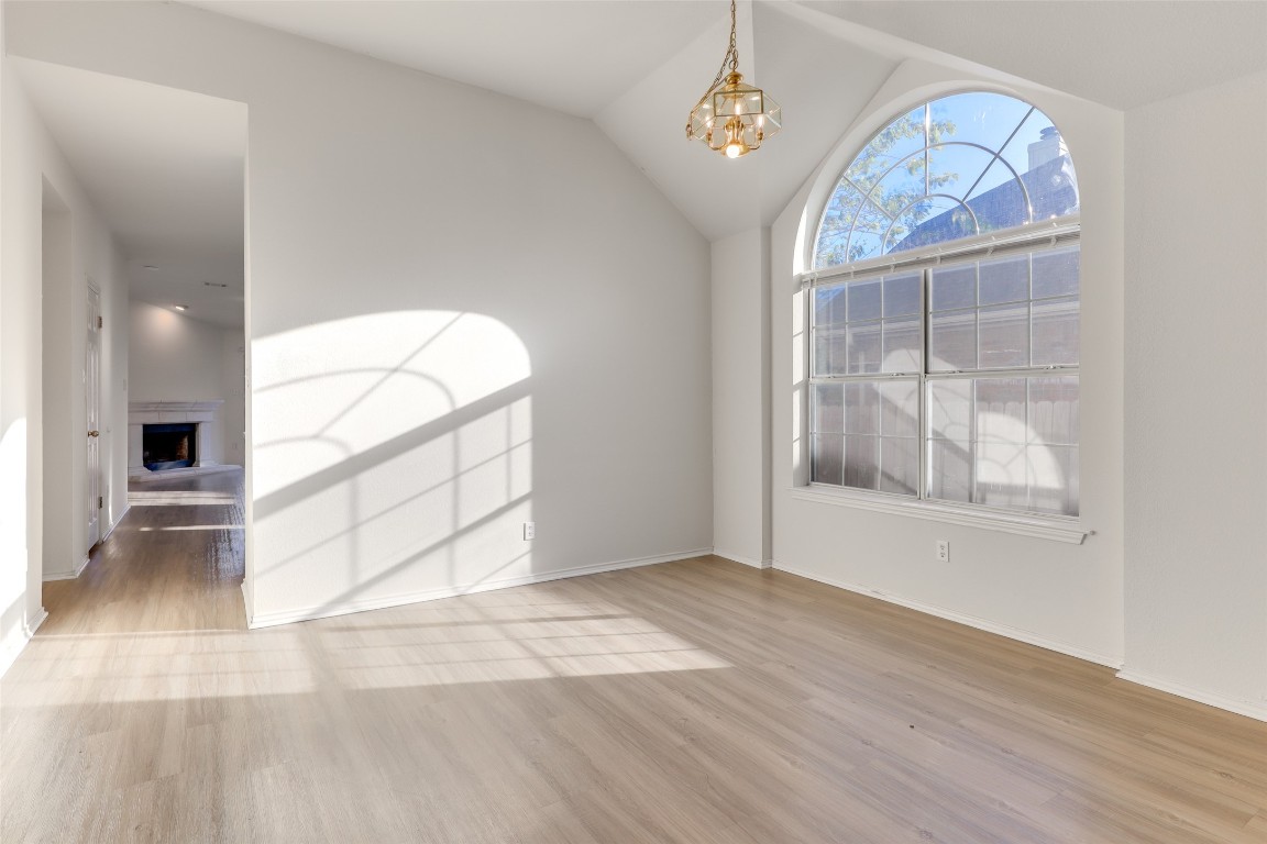 15437 Ozone Place Austin, TX 78728 - Photo 4 of 21 an empty room with wooden floor cabinet and windows
