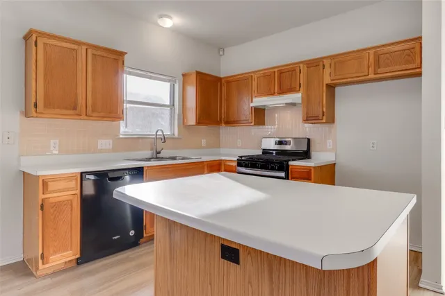 a kitchen with stainless steel appliances a sink dishwasher stove and refrigerator