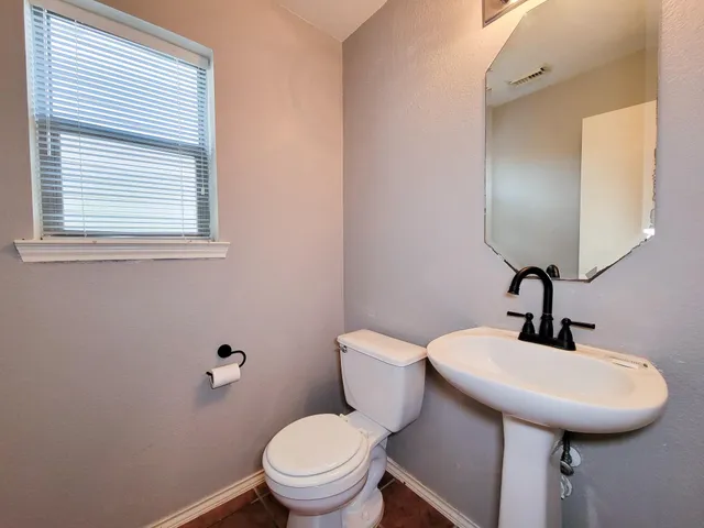 a bathroom with a toilet sink and mirror