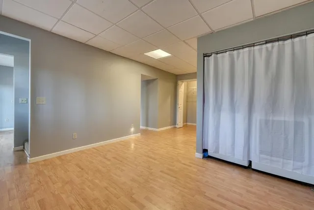 a view of an empty room with wooden floor and closet