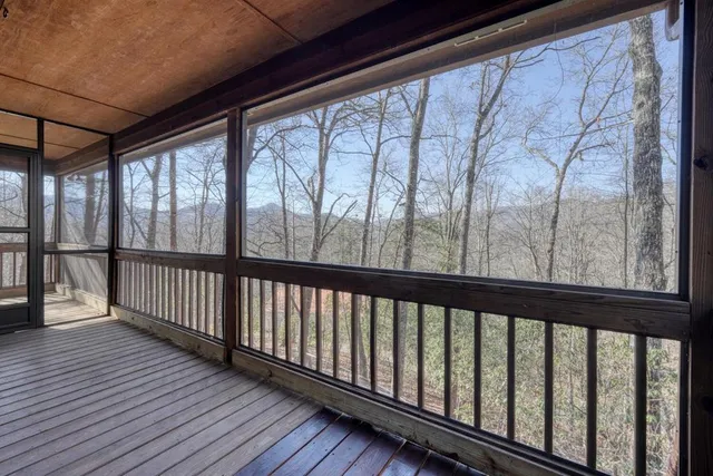 a view of a balcony with chairs and wooden fence