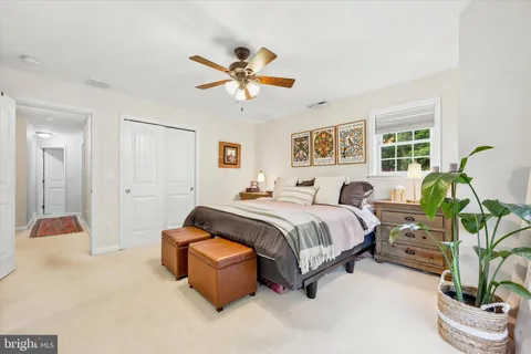 a spacious bedroom with a bed and ceiling fan