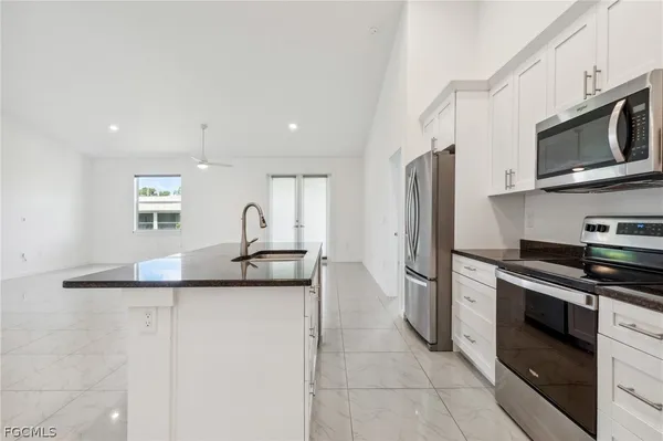 a kitchen with stainless steel appliances granite countertop a sink and a stove
