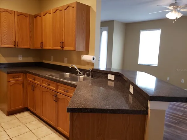 a kitchen with granite countertop a sink a stove and cabinets