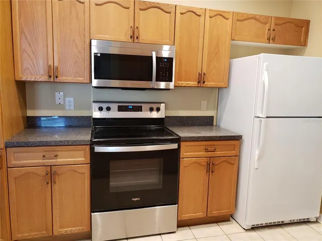 a kitchen with stainless steel appliances a stove microwave and refrigerator