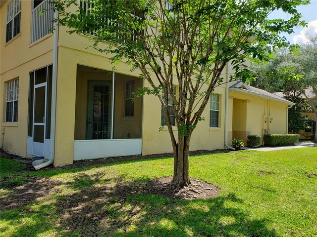 a view of a house with a tree in the yard
