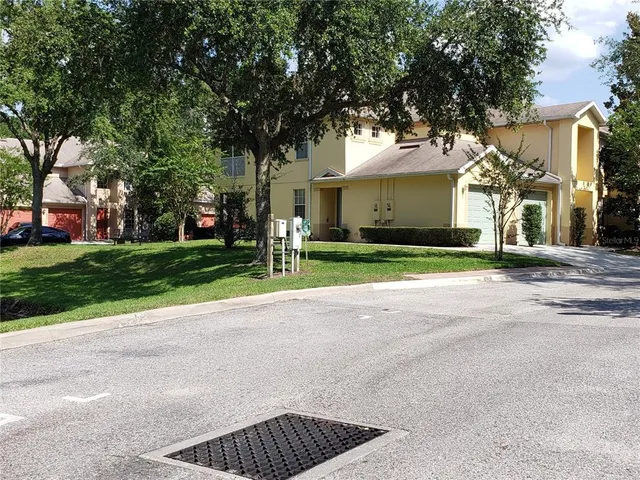 a front view of a house with a yard and trees