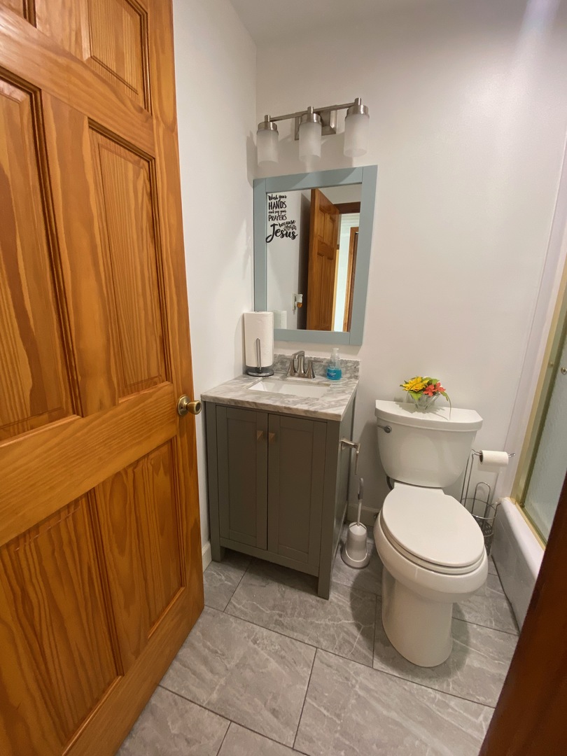 1927 Dugdale Road North Chicago, IL 60064 - Photo 12 of 36 a bathroom with a toilet a sink and a mirror