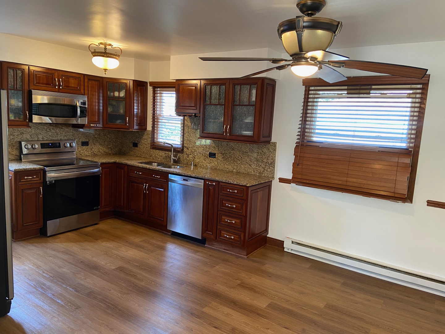 1927 Dugdale Road North Chicago, IL 60064 - Photo 6 of 36 a kitchen with stainless steel appliances granite countertop wooden floors and granite counter tops