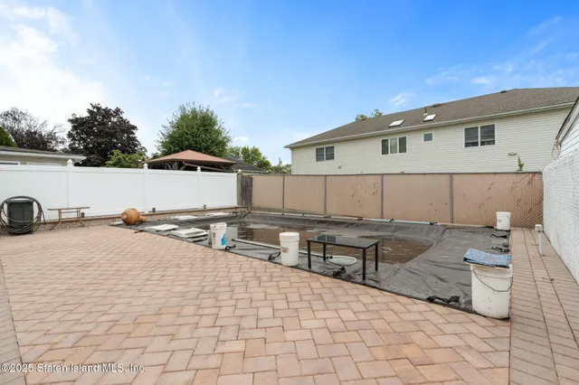 a view of a terrace with chairs and iron fence