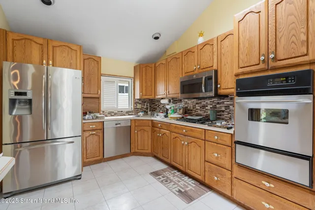 a kitchen with granite countertop a refrigerator stove and microwave