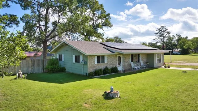 a front view of a house with yard and green space