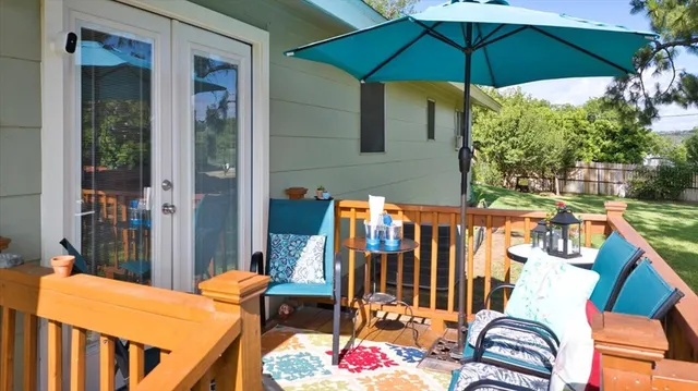 a backyard of a house with table and chairs under an umbrella