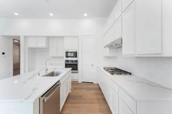 a kitchen with stainless steel appliances kitchen island granite countertop a sink and cabinets