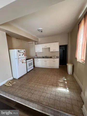 a large kitchen with kitchen island white cabinets and sink